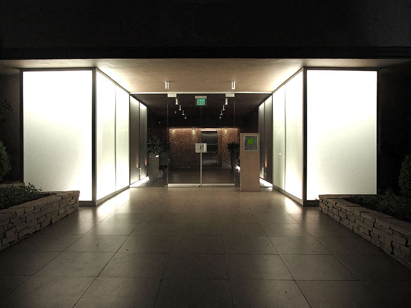 an office lobby at night with white walls and glass doors