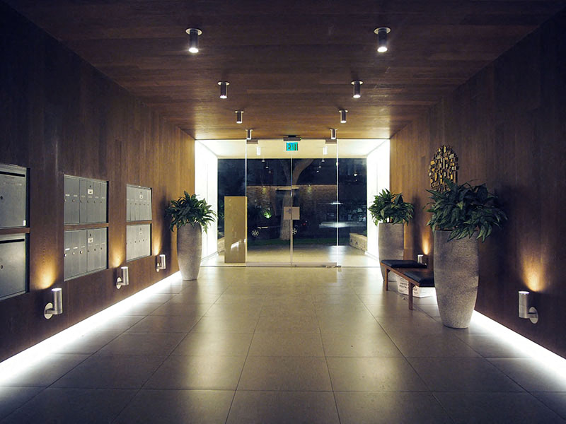 a large hallway with plants and a glass door