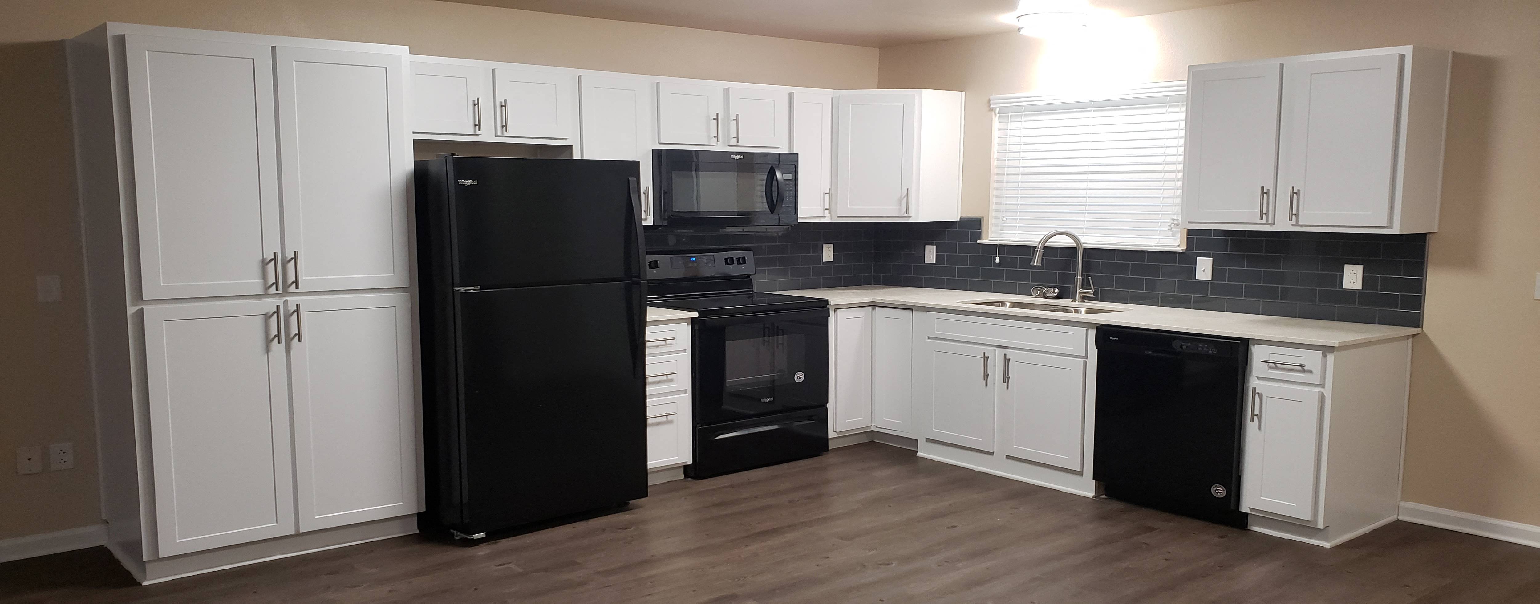 a kitchen with black appliances and white cabinets