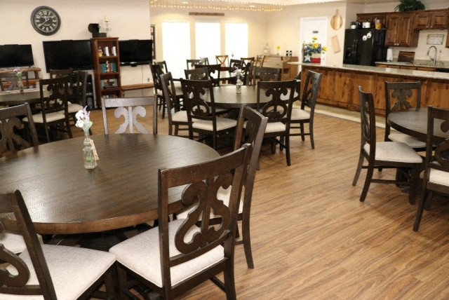 a dining room with tables and chairs and a kitchen