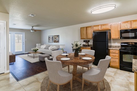 a living room and dining room with a table and chairs