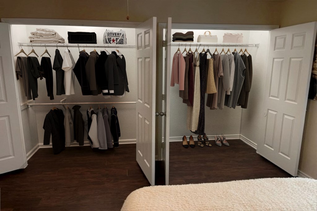 a closet with a bed and a rack of clothes in it