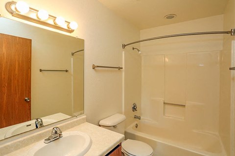 A bathroom with a white sink, toilet, and bathtub.