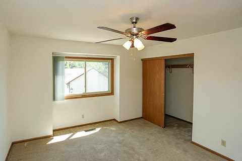 A room with a ceiling fan and a window.