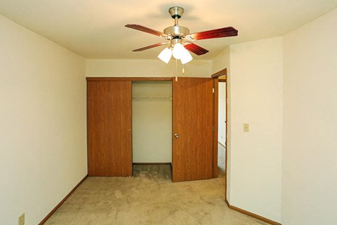 A room with a ceiling fan and two doors.