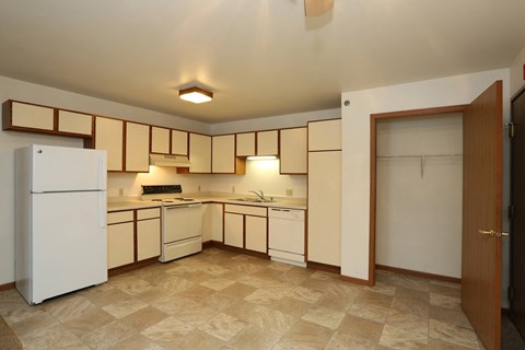 a kitchen with white appliances and cabinets and a refrigerator