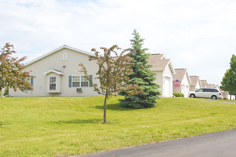 a house on a hill with a tree in the grass