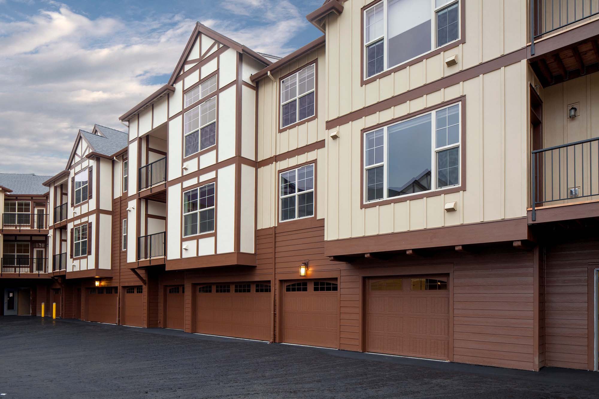 a row of town houses with brown garage doors