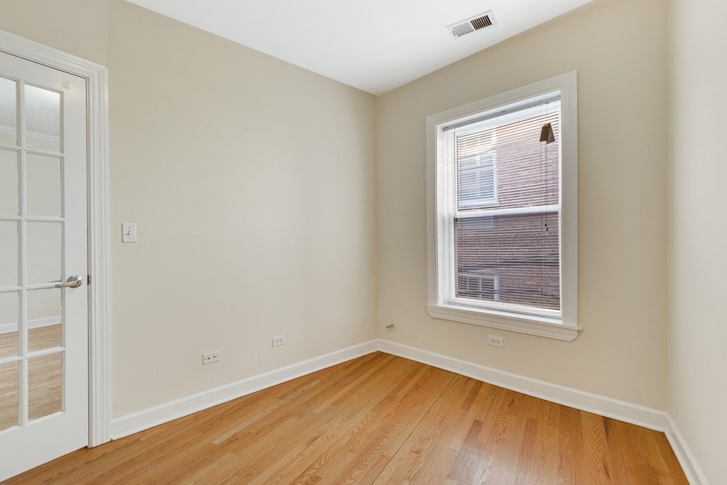 an empty room with wood floors and a window