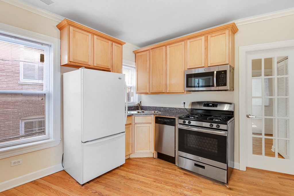a kitchen with wooden cabinets and appliances and a window