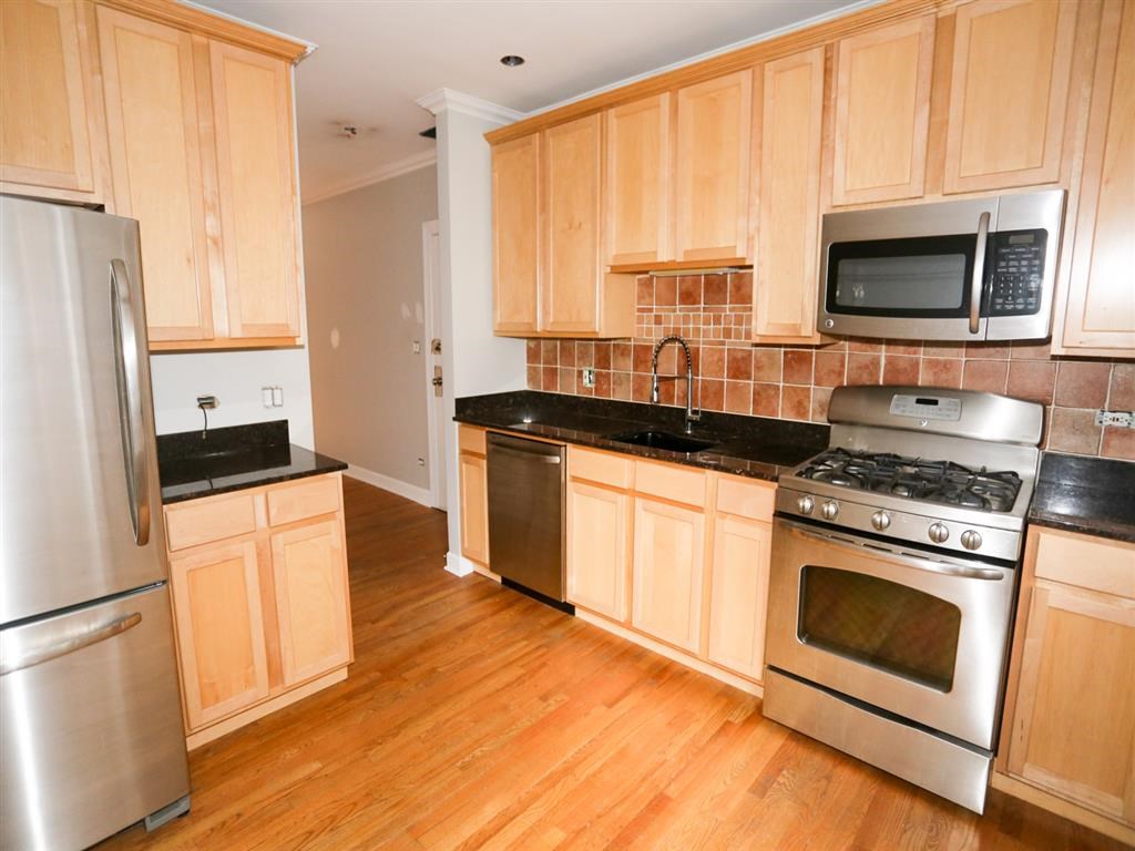 a kitchen with wooden cabinets and stainless steel appliances