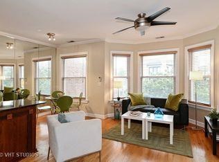 a living room with a couch and a table and a ceiling fan