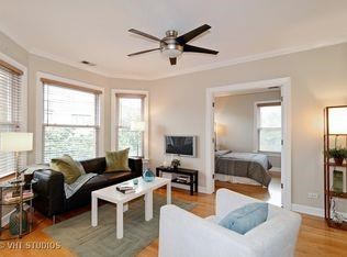 a living room with white furniture and a ceiling fan