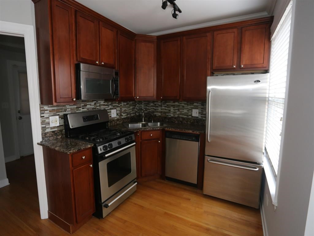 a kitchen with stainless steel appliances and wooden cabinets