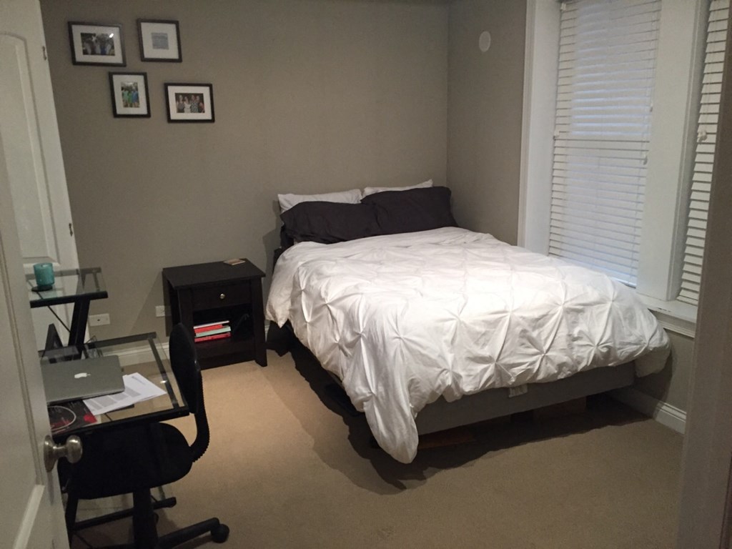 a bedroom with a bed and a desk and a chair