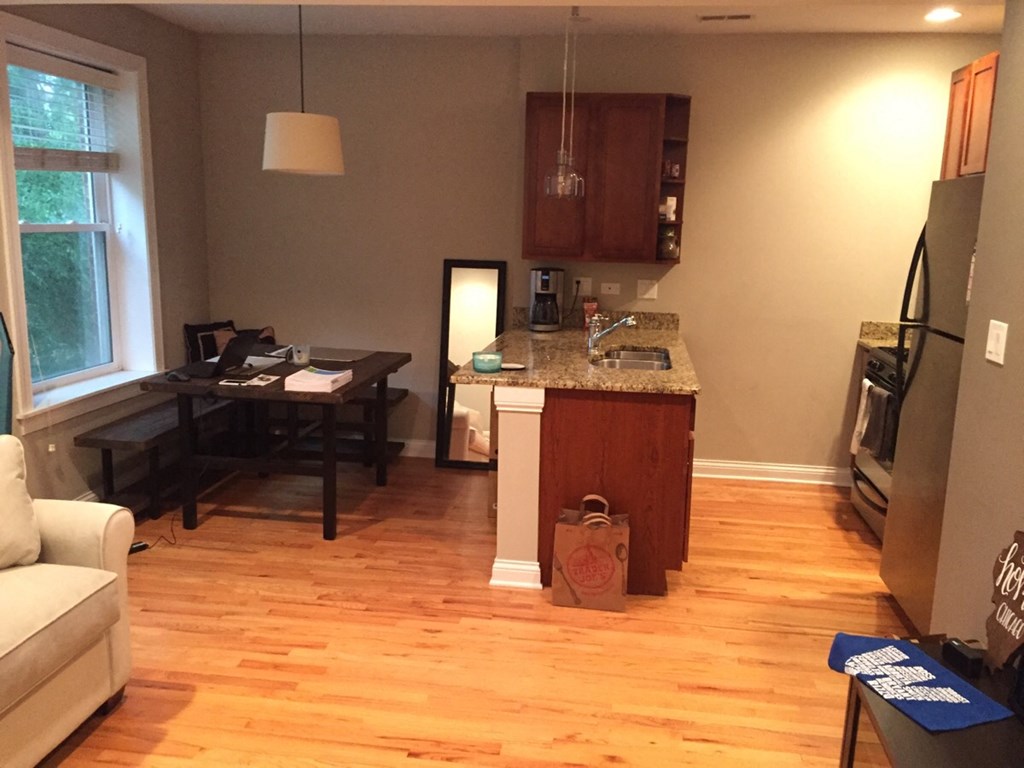 an open living room and kitchen with wood flooring