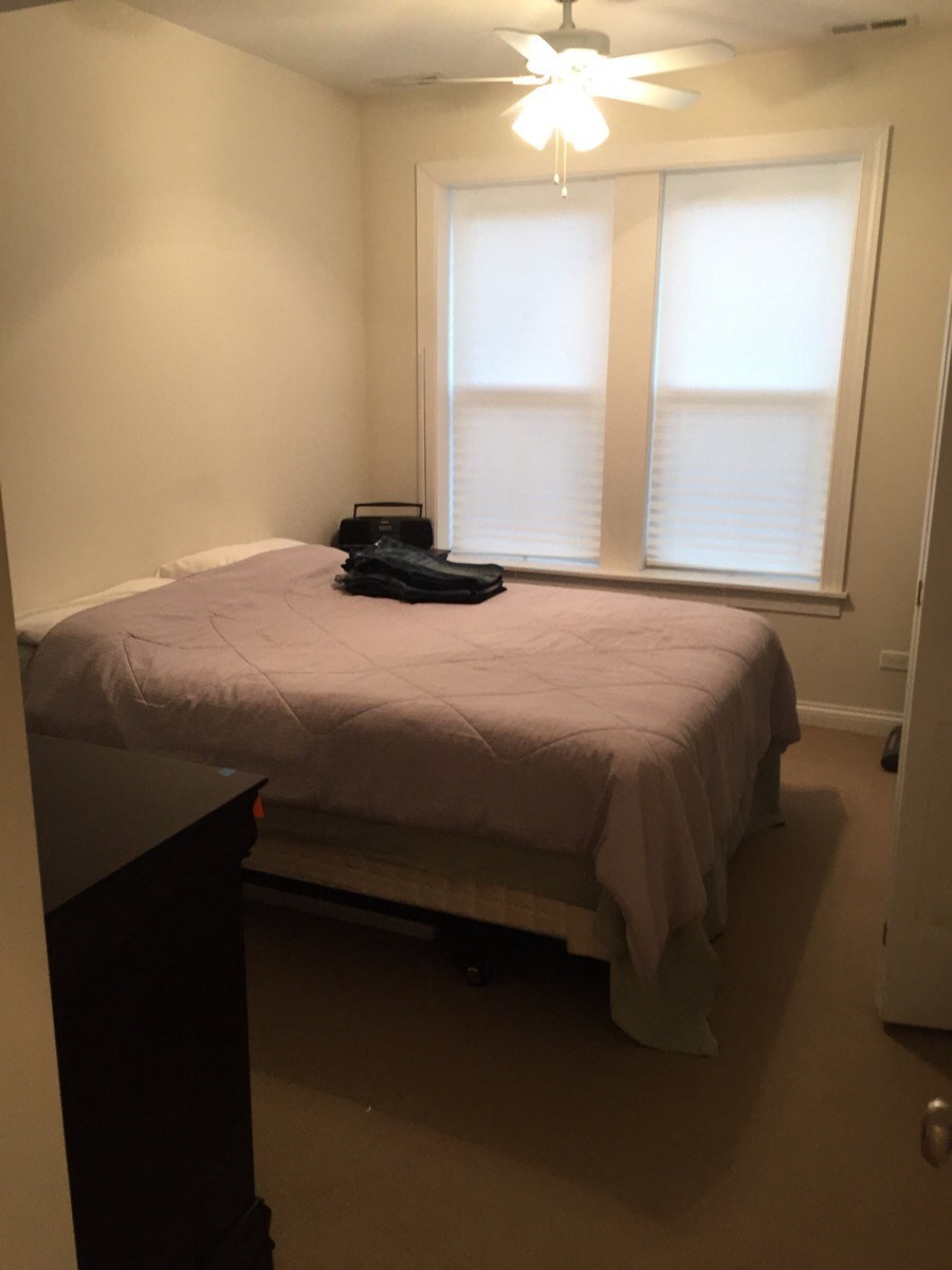 a small bedroom with a bed and two windows