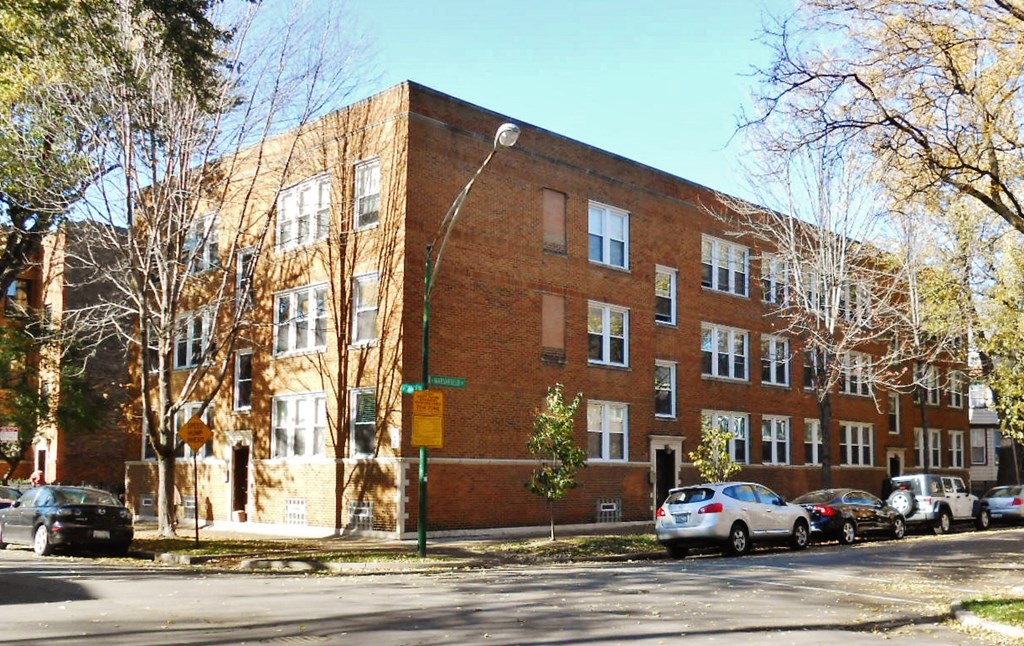 a brick building on a city street with cars parked