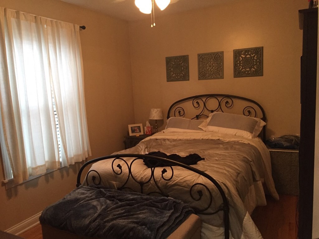 a bedroom with a bed and a large window