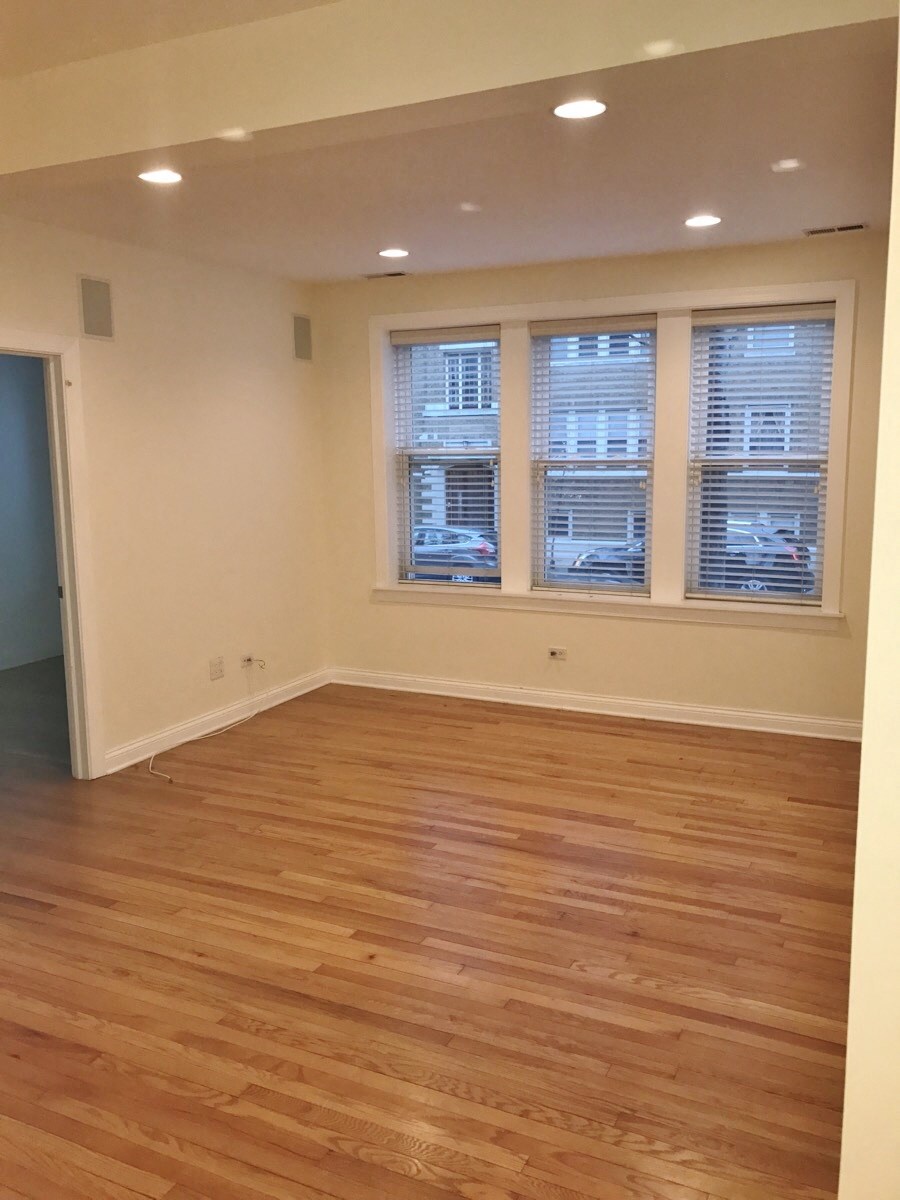 an empty living room with wooden floors and windows