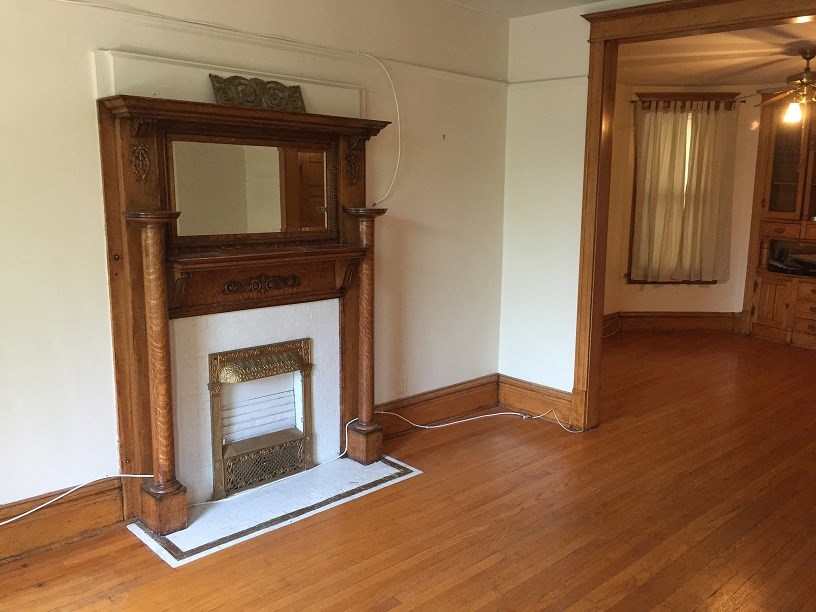 a living room with a fireplace and a wooden floor