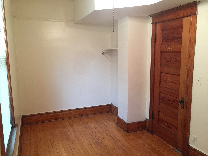 an empty room with a wooden floor and a closet