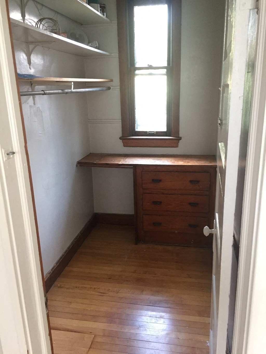 a small room with a desk and a window