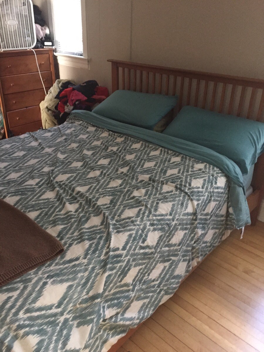 a bedroom with a bed with green pillows on it