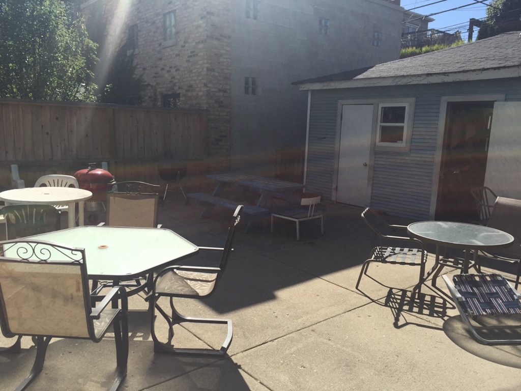 a patio with tables and chairs and a building in the background