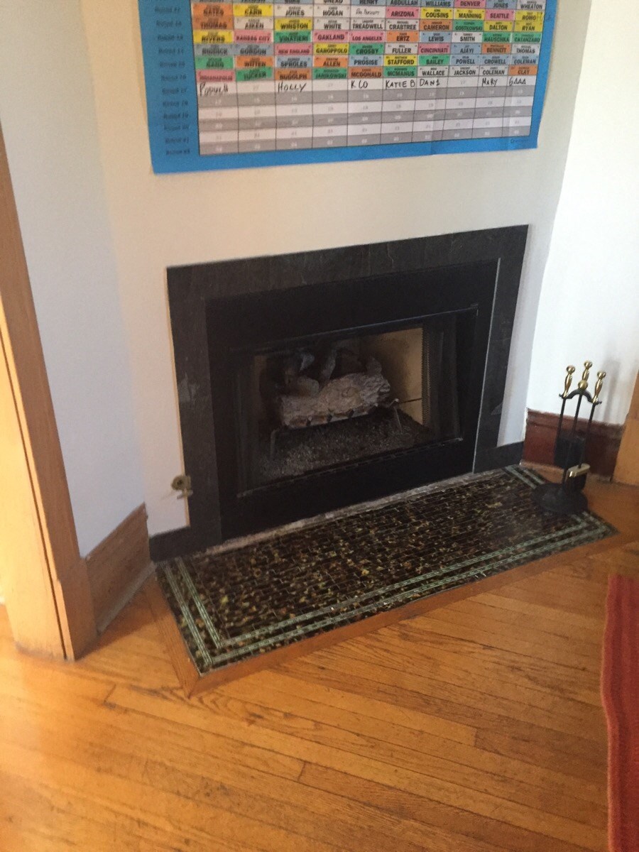 a fireplace in a living room with a rug in front of it