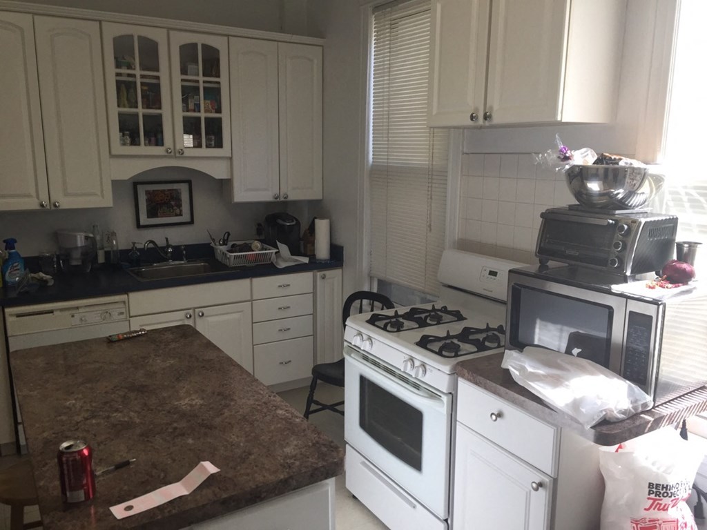 a kitchen with white cabinets and a stove and a microwave