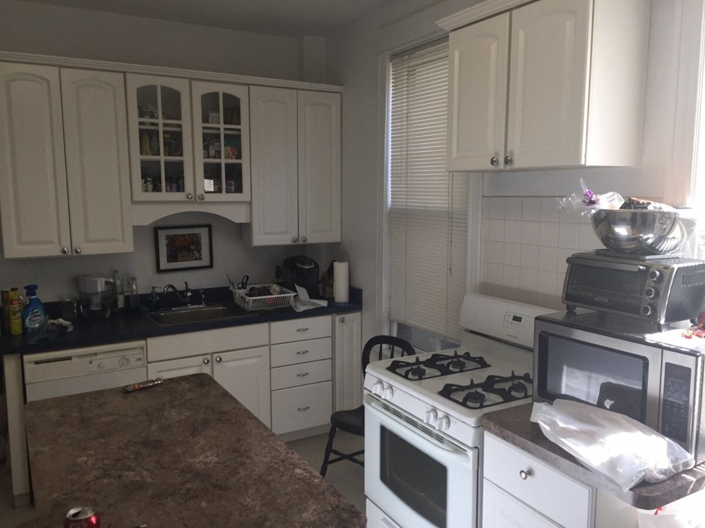 a kitchen with white appliances and white cabinets