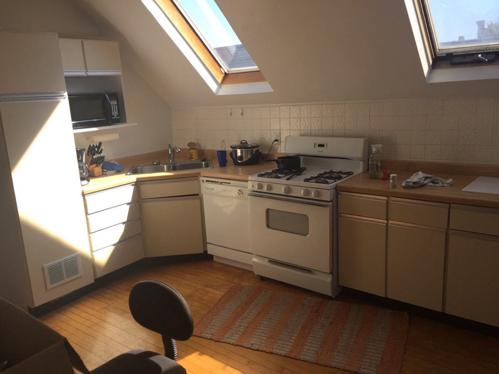 a kitchen with a stove and a sink and a window
