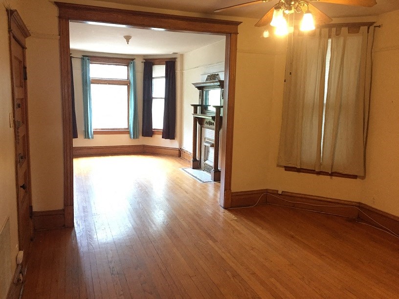 an empty living room with wooden floors and a window