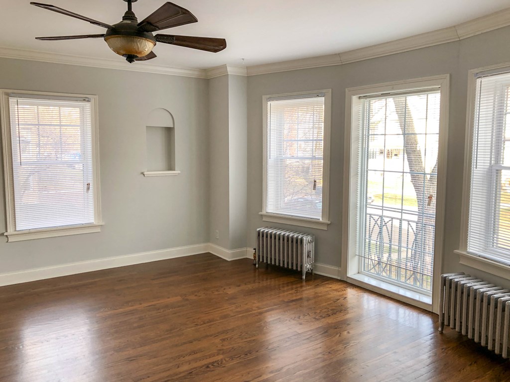 a living room with wood floors and a ceiling fan