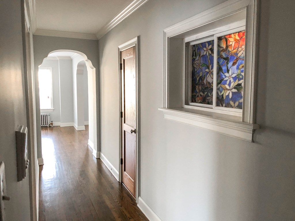 a view of a hallway with a window and a door
