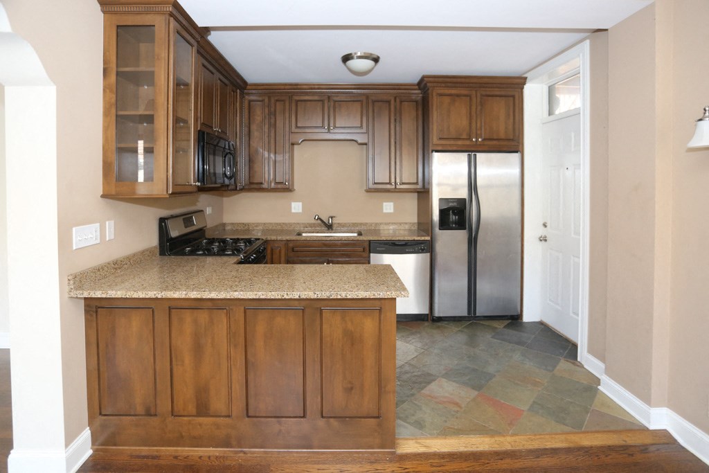 a kitchen with wooden cabinets and a granite counter top