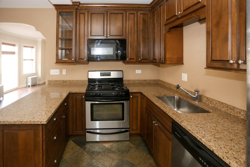 a kitchen with granite counter tops and wooden cabinets