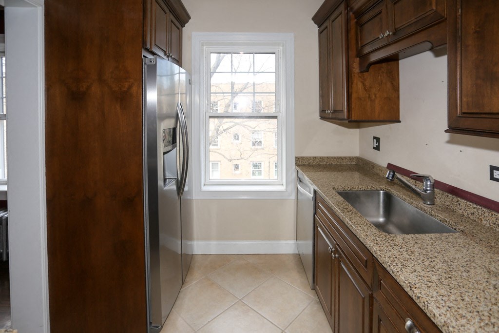 a kitchen with a sink and a stainless steel refrigerator