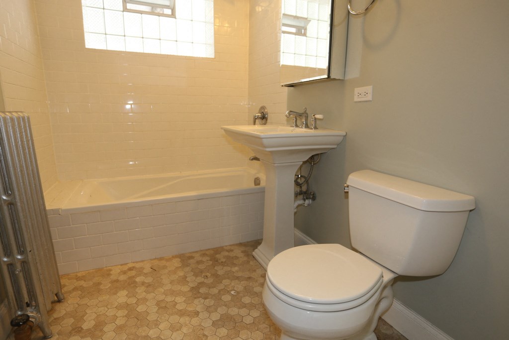 a bathroom with a toilet and a sink and a tub