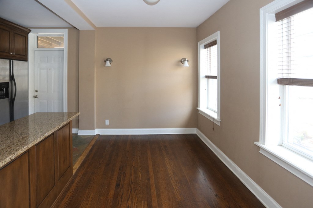 an empty kitchen with a hard wood floor and a window