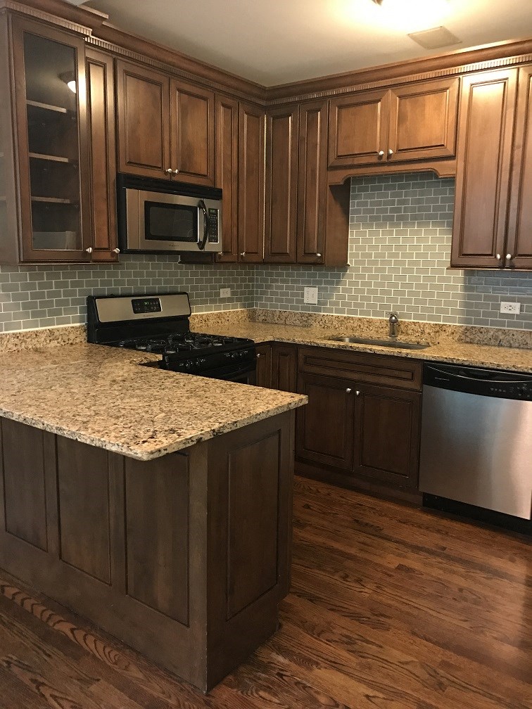 a kitchen with wooden cabinets and a granite counter top