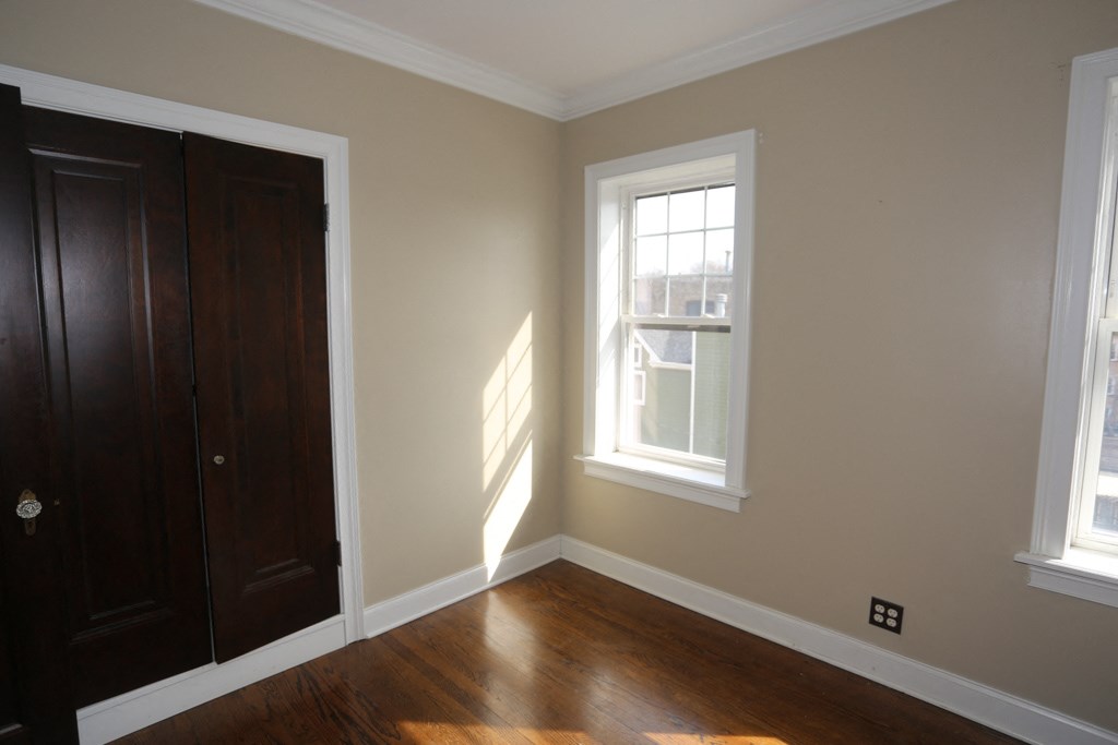 a room with a wooden floor and a wooden door and a window