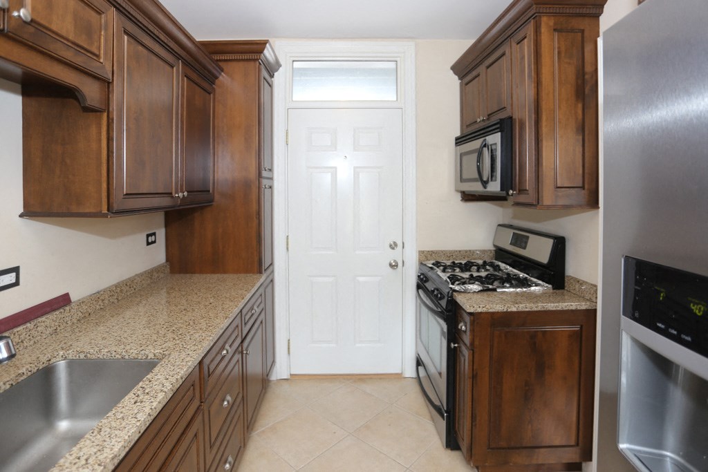 a kitchen with wooden cabinets and a white door