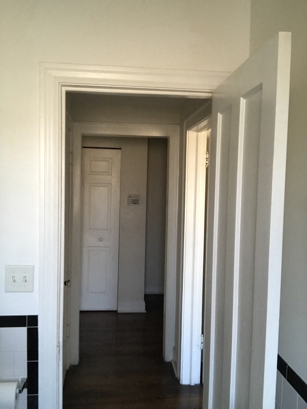 a room with a hallway and a closet and a white door
