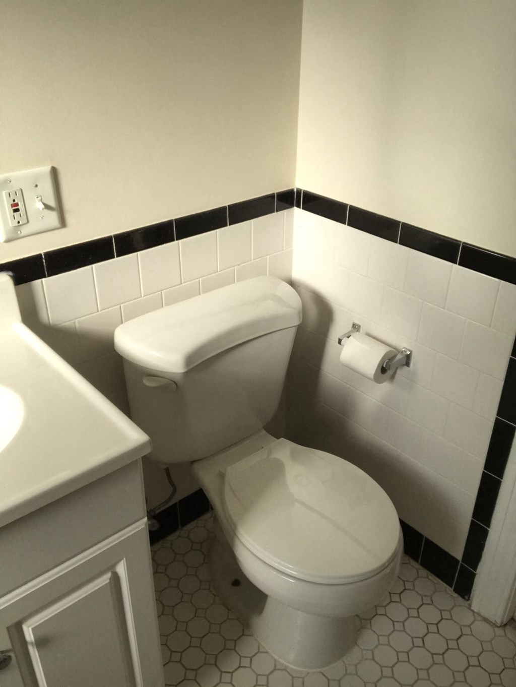a white toilet in a bathroom next to a sink