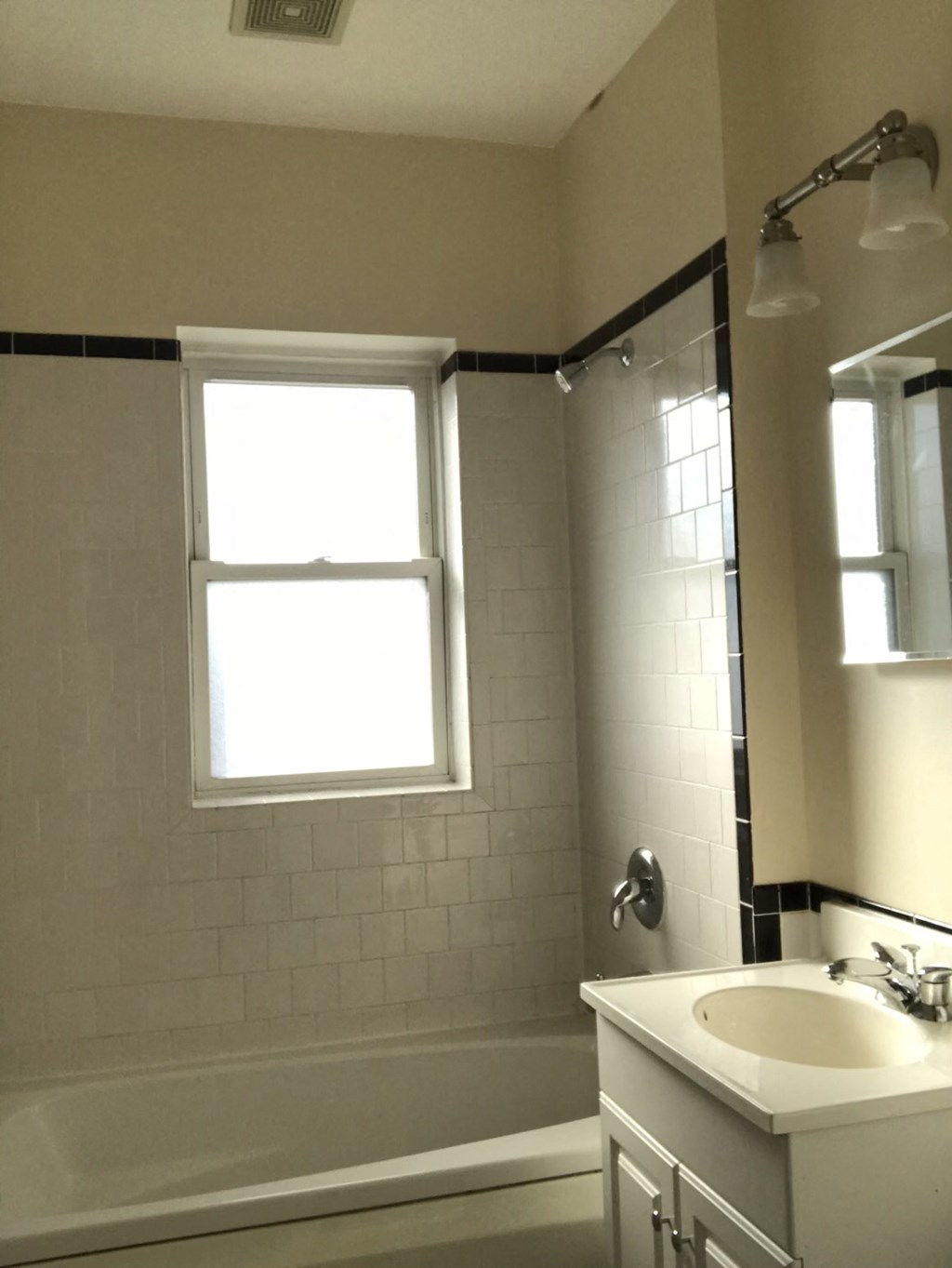 a bathroom with a sink and a shower and a window