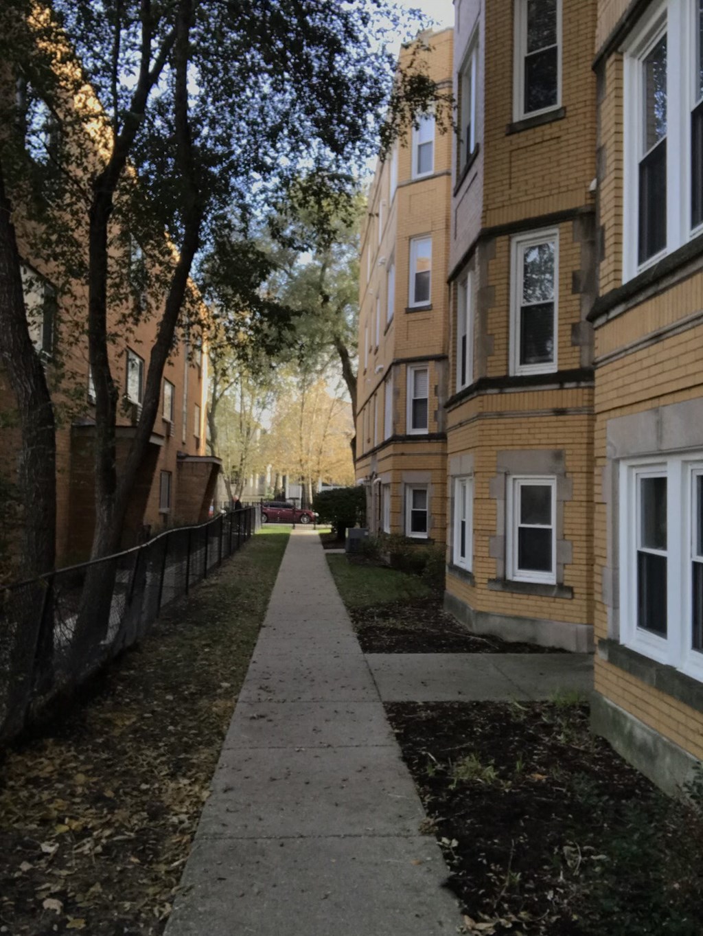 a sidewalk in front of a row of buildings