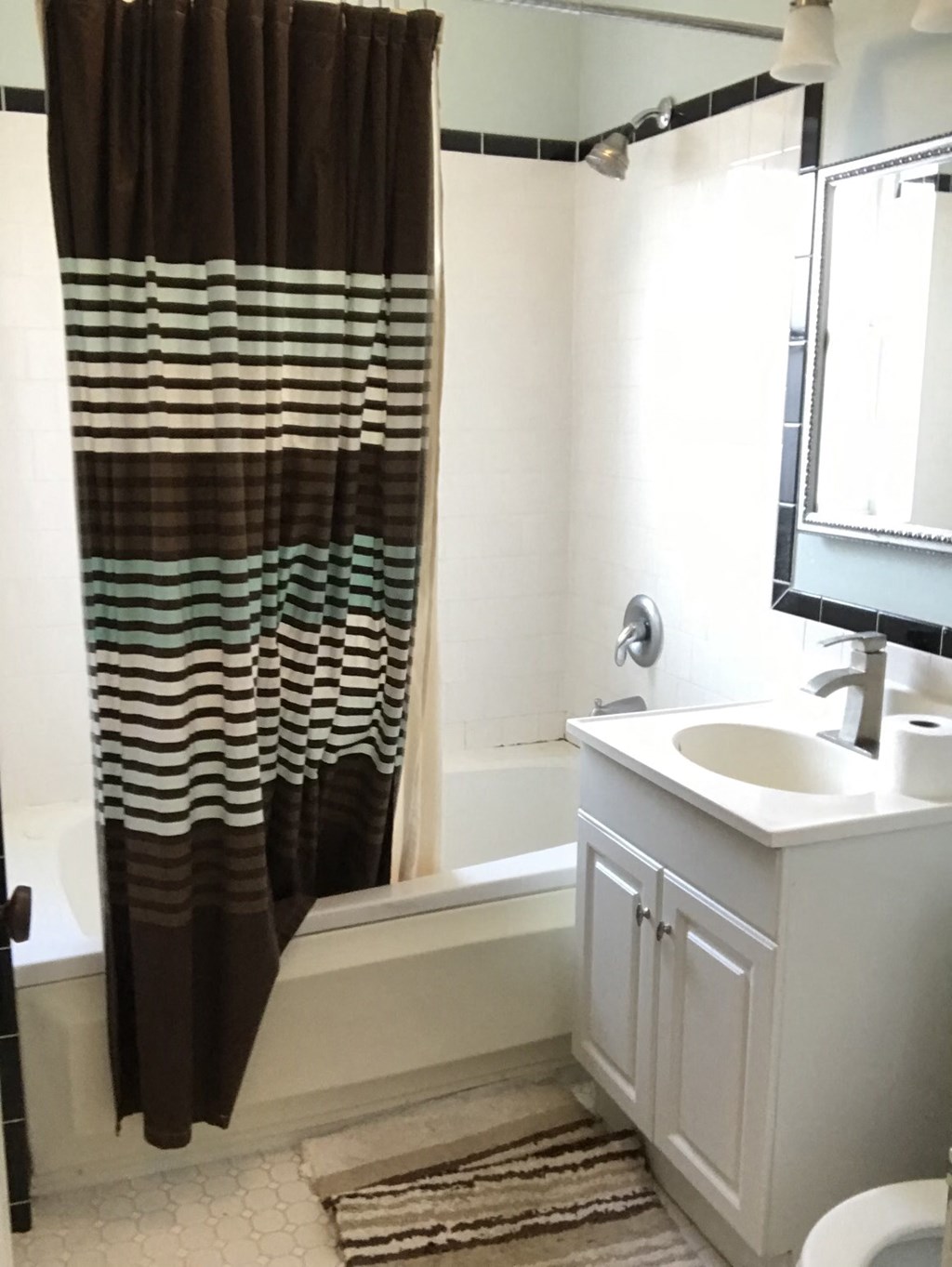a small bathroom with a shower curtain and a sink