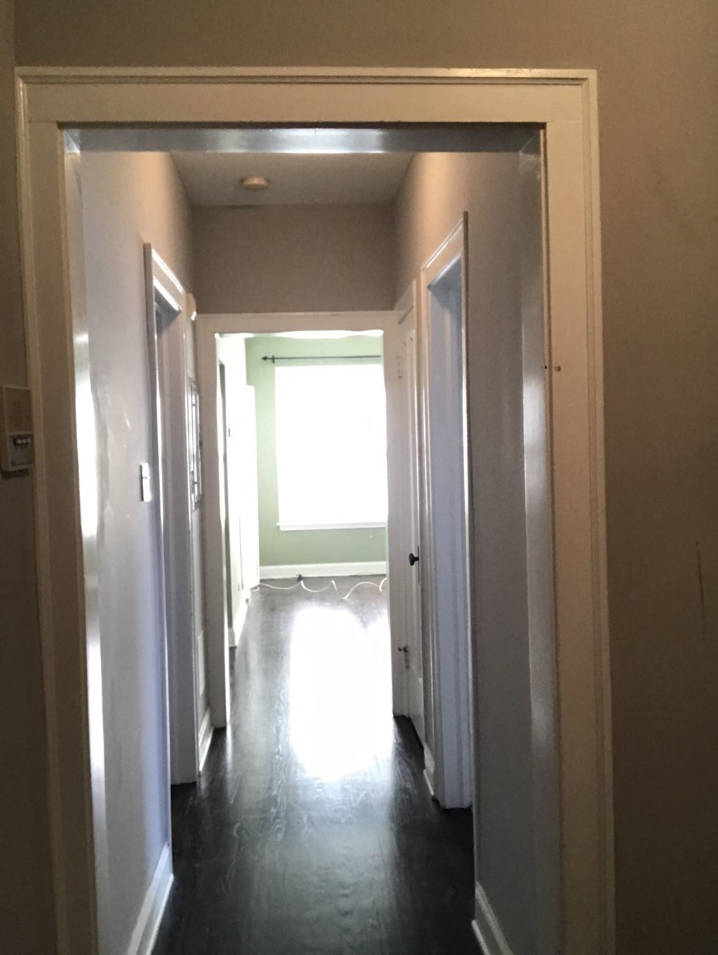 a look down the hallway of a house with open doors